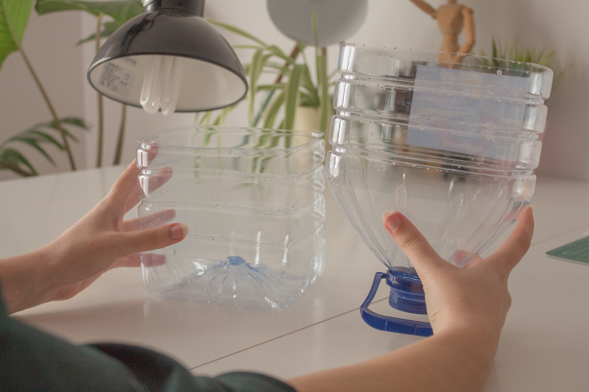 Holding a 5L water bottle cut in half over a craft table.