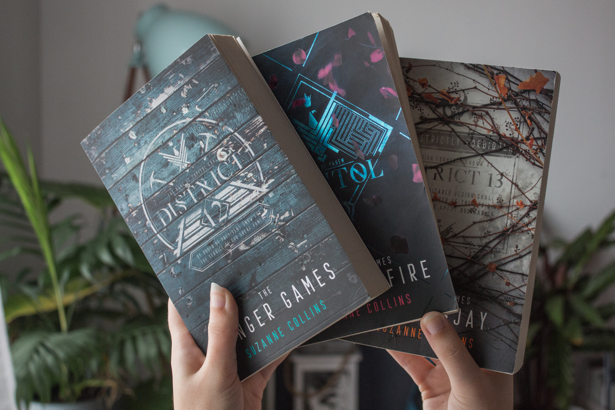Holding the three books in The Hunger Games series.