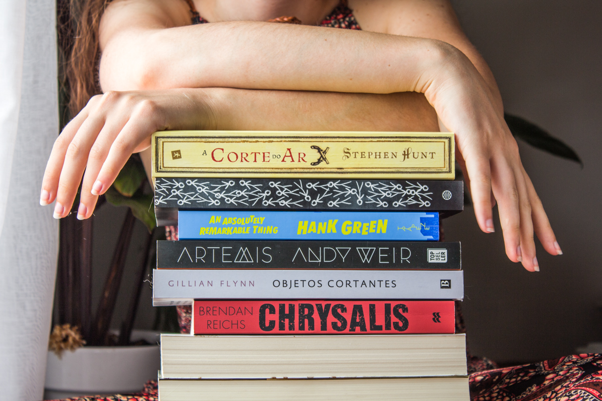 Arms resting on top a pile of books.