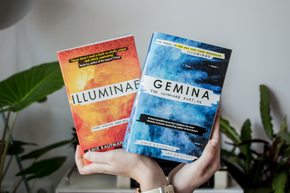 Holding the books Iluminae and Gemina next to each other.