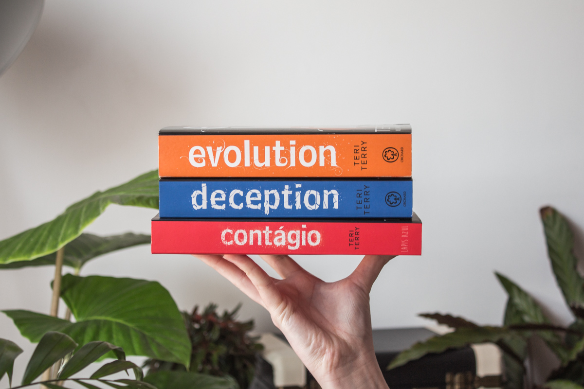 Holding a stack of the three books in the Dark Matter series.