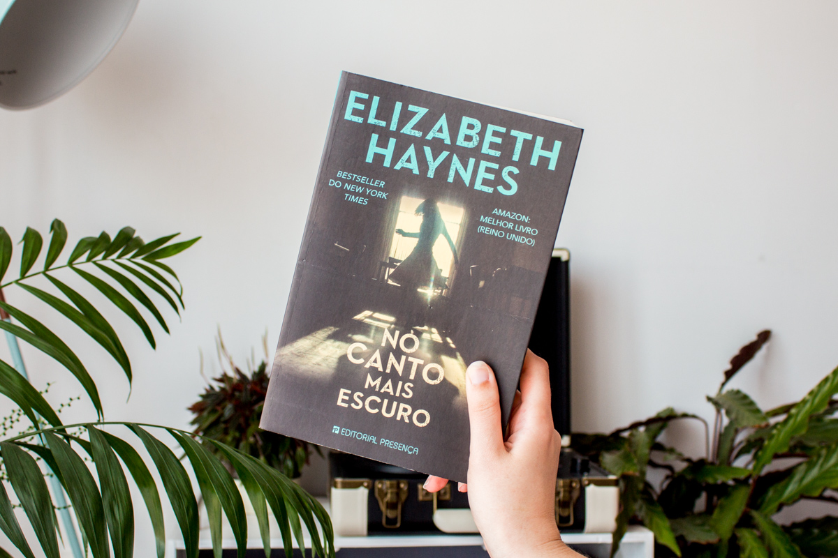 Holding a copy of Into the Darkest Corner by Elizabeth Haynes.