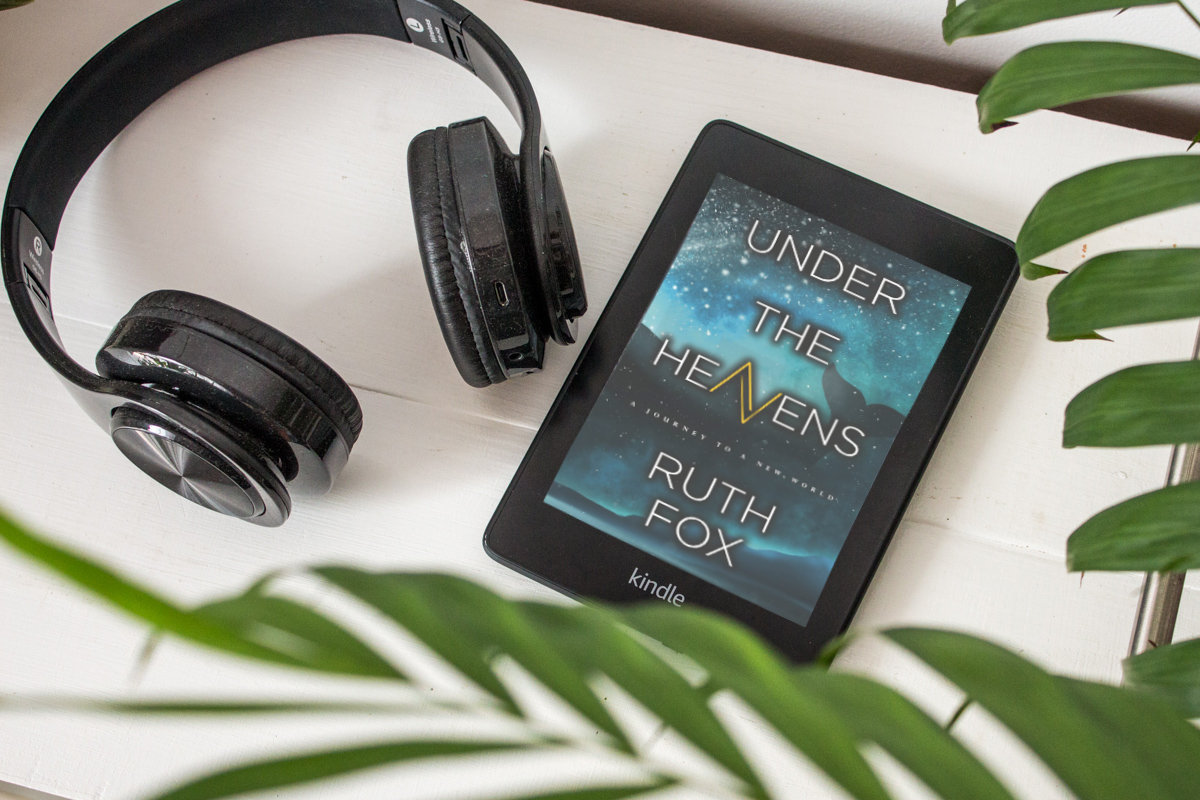 Kindle Paperwhite showing the cover of the book next to headphones.