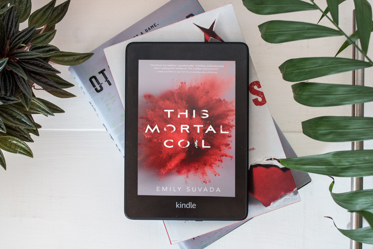 Kindle Paperwhite with full colour cover of This Mortal Coil by Emily Suvada.