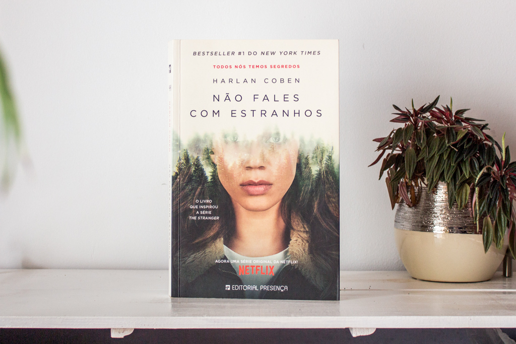 Holding from the top a copy of the book with the tie-in movie over.