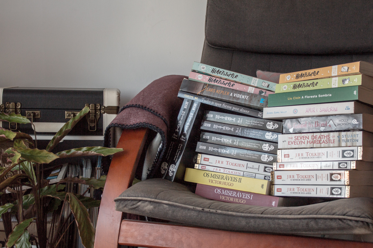 Two piles of books on an armchair.