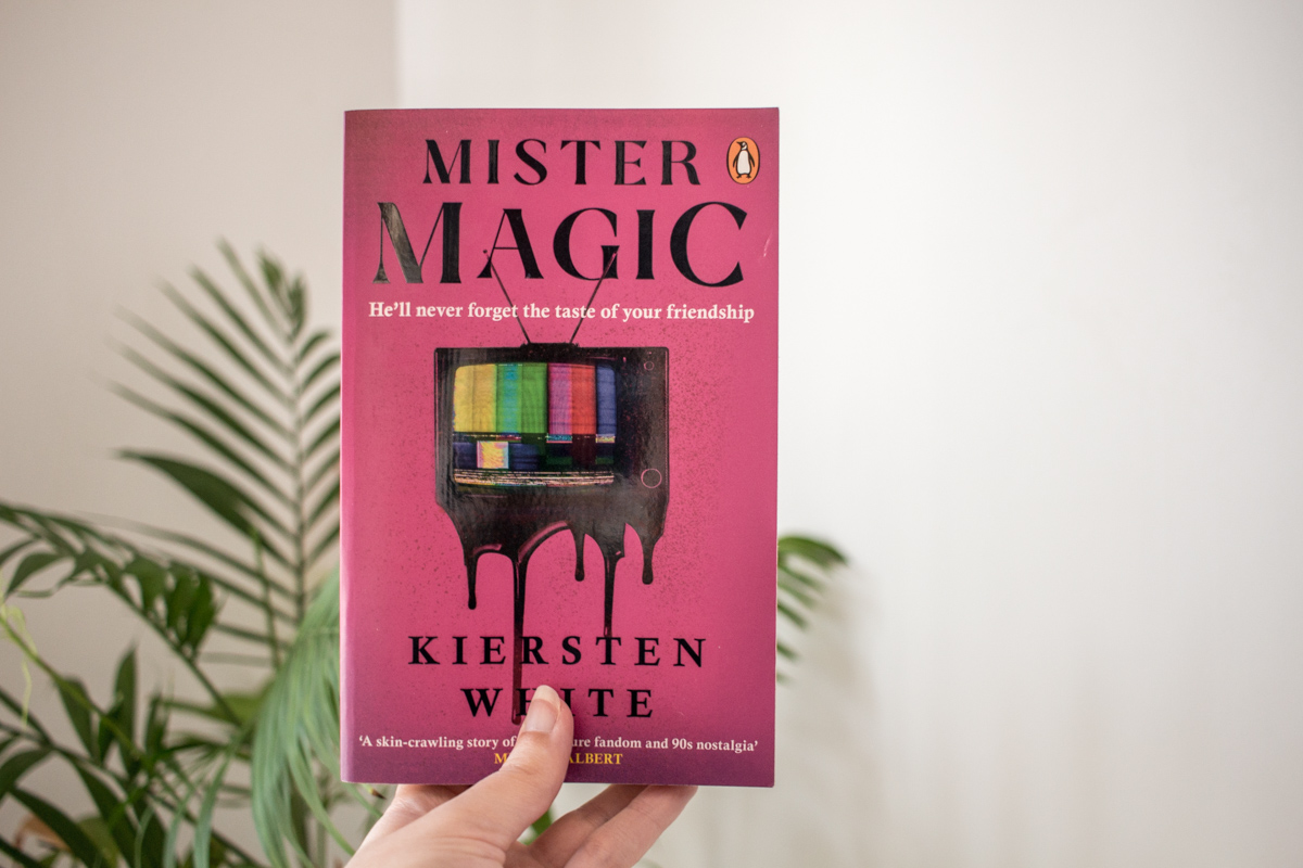 Holding with one hand a copy of Mister Magic.